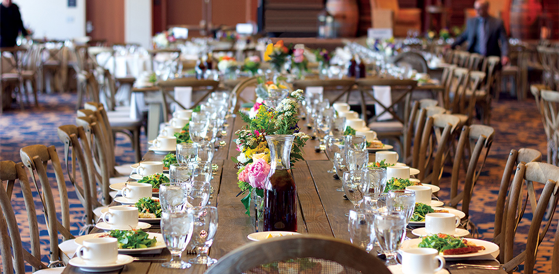 Large table setup with plates and glasses and chairs for a formal event